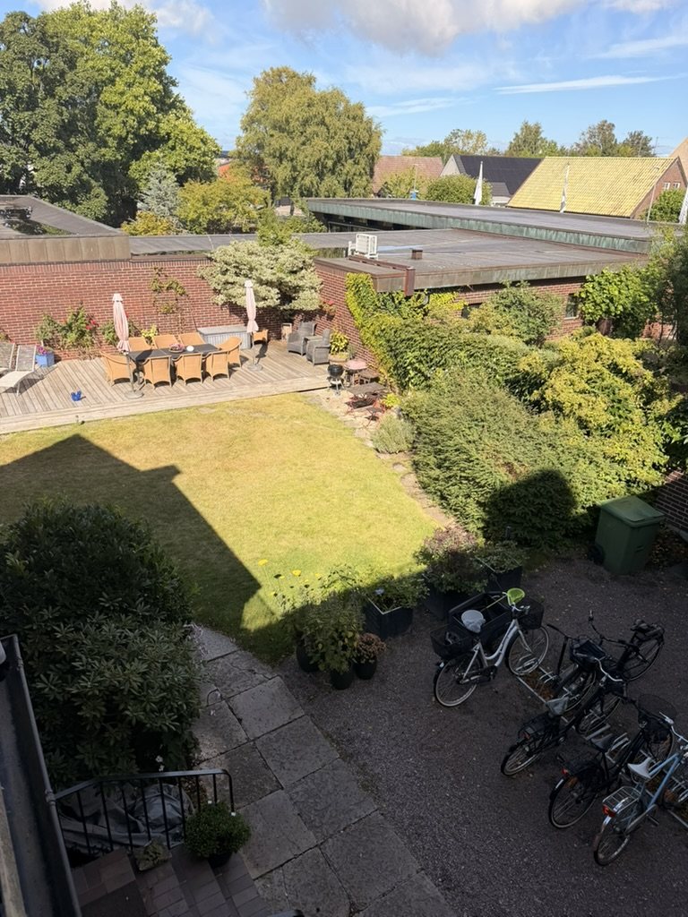 Doktorsvillans innergård med trädäck och grönska